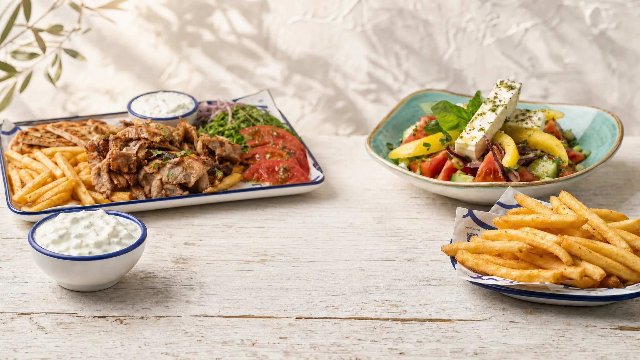 Gedeckter Tisch bei MyPita: Souvlaki Pita, Gyros Teller, Tsatsiki, Choriatiki und Pommes